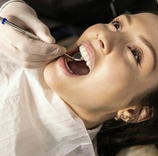 Close-up portrait of a woman receiving a dental checkup in a clinic setting.