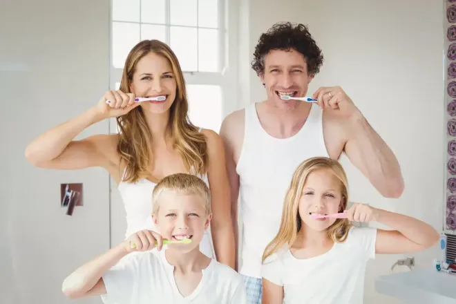 A family of 4 brushing their teeth